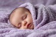© LimeSky - Gentle image of a serene sleeping newborn on a bed wrapped in a purple blanket Wishing sweet dreams and a good night embodying family and maternal love