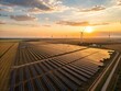 © Khadiza - Golden sunset over vast solar farm and wind turbines