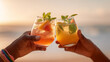 © dinatychynska - Summer cocktails cheers at beach sunset with mint garnish and ice. Tropical mocktails toasting celebration for vacation lifestyle, golden hour drinks and refreshing beverages party concept.