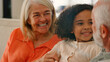 © Monkey Business - Granddaughter Cuddling With Loving Grandparents On Sofa At Home