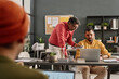 © TrueFrame Collective - Over-the-shoulder shot of two Indian men wearing stylish smart casual clothes working together in modern office