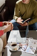 © TrueFrame Collective - High angle view of two unrecognizable men sitting in modern office discussing business project