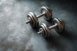 © EricMiguel - Pair of vintage metal dumbbells resting on textured gym floor for strength training and fitness workouts