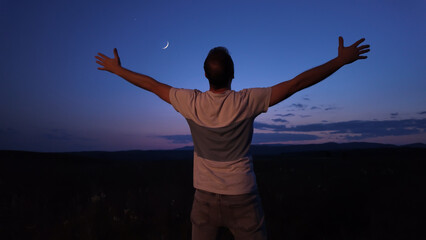 Wall Mural - man with arms wide open enjoying outdoors under stars, planets and moon.
