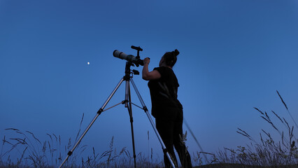 Wall Mural - amateur astronomer using telescope for watching stars, moon, planets and other celestial objects fro