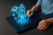 © praewpailyn - Digital learning in smart classroom uses educational technology to inspire creativity as child draws glowing rocket and planet on tablet with stylus pen