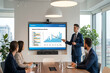 © Creative Hero - Business team in conference room watching male presenter point at quarterly performance review on large screen