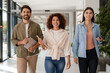 © Maria Vitkovska - Smiling businesspeople walking together in office hallway