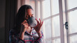 © Monkey Business - Woman At Home Looking Out Of Window Drinking Hot Drink From Mug