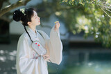 Young woman in traditional attire admiring a flower Chinese word means flower.