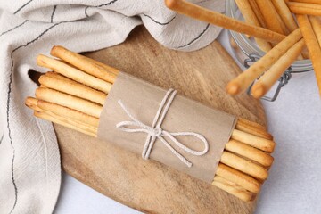 Wall Mural - delicious grissini sticks on light grey table, flat lay