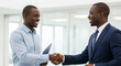 © Octara - Two Smiling African American Professionals Sealing a Business Deal with a Handshake.