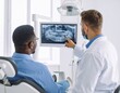 © Tasha - A dentist points to a patient's x-ray, explaining the diagnosis.