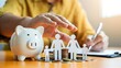 © Md Fazly Rabby - Businessman take a position to protect on the piggybank and paper family in hand, donation, saving, charity, family finance plan concept, fundraising, superannuation, financial crisis concept.