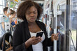 © Anna Berkut/Stocksy - woman in tramway using smartphone, public transport