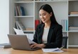 © MdMashud - Young asian woman working on a laptop in an office setting