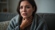 © Ridz - Concept of illness and health problems: A sick woman with symptoms of a cold, flu, or tonsillitis.