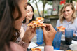 © Sean Locke/Stocksy - Dining: Young Woman Eating Slice Of Hawaiian BBQ Pizza