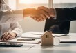 © Asifur Rahman - Successful real estate deal closing with handshake and house model