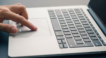 Finger Navigating Laptop Touchpad for Efficient Workflow in Modern Office Environment