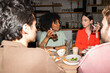 © Basil Pind/Stocksy - Friends Talking and Drinking Beer at Sushi Restaurant