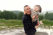 © Iuliia Versta/Stocksy - Grandfather holding laughing grandson Outdoors