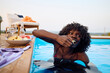 © Boris Jovanovic/Stocksy - Woman eats fruit in the pool