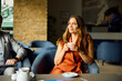 © Boris Jovanovic/Stocksy - Woman drinks coffee in the hotel lobby