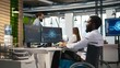 © DC Studio - IT professional in wheelchair in inclusive office developing software applications using AI automation. Computer scientist with paraplegia debugging applications with artificial intelligence, camera A