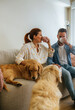 © Marco Govel/Stocksy - Couple drinking coffee with dogs