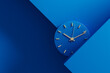 © Marcos Osorio/Stocksy - Minimalist clock showing time in a modern blue setting