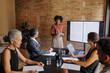 © BONNINSTUDIO/Stocksy - Lawyer giving presentation to colleagues in office meeting room