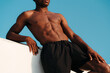 © Lucas Ottone/Stocksy - Unrecognisable athletic young black man with fit abs and torso