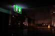 © Jovo Jovanovic/Stocksy - Green exit sign glows in dark, reflecting city lights.