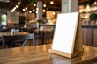 © shahjalal - Blank white tent card menu holder on wooden table in cozy cafe interior. Perfect for restaurant menu mockups, product display, advertising, promotions, and warm ambient lighting backgrounds.