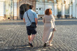 © Popescu - Fat couple walking on the city street and enjoying a sunny day. Rear view of overweight young couple wearing  casual summer clothes walking in the town square. Urban street life