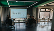 © qunica.com - Group of colleagues engaged in a business presentation within a stylish conference room setting.