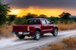 © Space Priest - Red pickup truck on dusty road at sunset in african savanna landscape