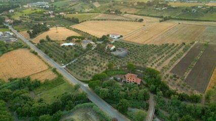 Wall Mural - aerial view capturing golden hour light cascading over verdant tuscan landscape, revealing winding r