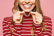 © ViDi Studio - Close up cropped photo of young smiling woman wear red striped sweatshirt casual clothes hold in hand invisible transparent aligners, invisalign dental braces isolated on plain pink background studio.