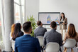 © Dusan Petkovic - Young female data analyst is standing in boardroom in front of audience and presenting data statistics.