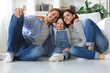 © ty - Young Caucasian family with small daughter pose relax on floor in living room, smiling little girl kid hug embrace parents, show love and gratitude, rest at home together.