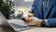 © Father_Studio - Close-up of businessman using smartphone to check product ratings on a marketplace website before making a cashless credit card payment. Online shopping and customer behavior concept.