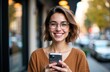 © starush - Smiling woman using smartphone outdoors on city street