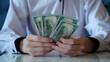 © fifthplanet - Close-up of a man hands holding a US dollar bills