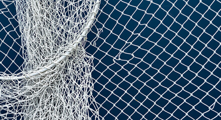 Fishing net with a white rope on a blue background, top view flat lay