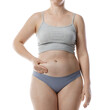 © New Africa - Liposuction. Woman in underwear touching her belly on white background, closeup