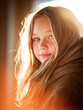 © Kowit - A young person with long hair, wrapped in a cozy shawl, glows warmly in soft, golden light.