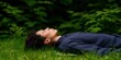 © ANGEL4289 - Digital detox lifestyle concept. A person relaxing in grass surrounded by greenery.