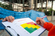 © Nattawit - Action of a project manager is writing on risk assessment matrix form to rating the risk of house building structure or building quality (as blurred background. Industrial working scene, close-up.